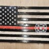 A wooden american flag with the red line painted on it.