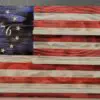 A wooden american flag with the words " 7 6 " painted on it.